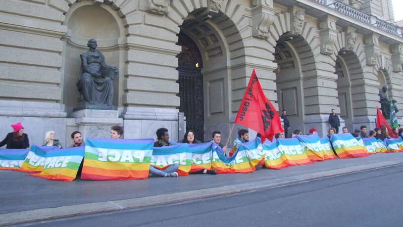 Aktivistinnen und Aktivisten bildeten eine Menschenkette vor dem Bundeshaus und forderten damit das Parlament auf, sich für eine konsequente Friedenspolitik einzusetzen.