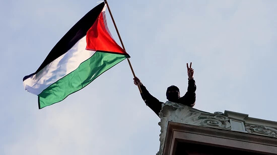 dpatopbilder - Ein protestierender Student schwenkt eine palästinensische Flagge über der Hamilton Hall auf dem Campus der Columbia University. Foto: Mary Altaffer/AP Pool/dpa