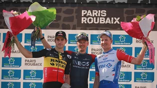 Das Podest des Klassikers Paris - Roubaix 2022: Sieger Dylan van Baarle (mitte), Wout van Aert (links/2.) und Stefan Küng (rechts/3.)