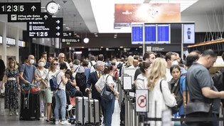 Menschen warten am Flughafen Zürich auf ihren Abflug in die Ferien. (Archivbild)