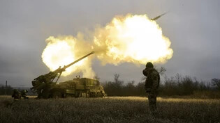 ARCHIV - Ukrainische Soldaten feuern eine Haubitze auf russische Stellungen. Foto: Libkos/AP/dpa