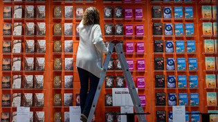 dpatopbilder - Eine Mitarbeiterin bestückt den Stand von Droemer Knaur auf der Leipziger Buchmesse. Foto: Hendrik Schmidt/dpa
