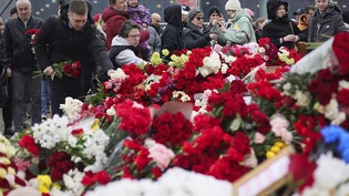 Menschen legen Blumen und Spielzeug am Ort des Anschlags ab. Foto: Vitaly Smolnikov/AP/dpa