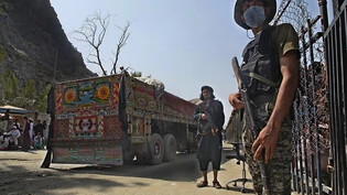 ARCHIV - Ein pakistanischer Soldat (r) und Kämpfer der Taliban stehen Wache an einem Grenzübergang zwischen Pakistan und Afghanistan in der Provinz Khyber Pakhtunkhwa auf den jeweiligen Seiten der Länder. Foto: -/AP/dpa