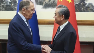 HANDOUT - Wang Yi (r), Außenminister von China, begrüßt seinen russischen Kollegen Sergej Lawrow. Foto: Uncredited/Russian Foreign Ministry /APPress Service/AP/dpa