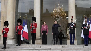 Emmanuel Macron (3.v.r), Präsident von Frankreich, und Menna Rawlings (M), Botschafterin von Großbritannien in Frankreich, stehen mit britischen Soldaten und der republikanischen Garde am Elysee-Palast. Foto: Thibault Camus/AP/dpa