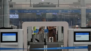 ARCHIV - Passagiere warten an einem Abfertigungsschalter auf dem internationalen Flughafen Rom-Fiumicino. Foto: Gregorio Borgia/AP/dpa