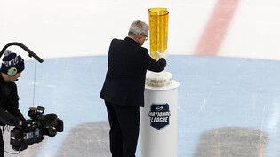 Das Objekt der Begierde: Willi Vögtlin, der Meister der Liga-Spielpläne, platziert den Pokal in der Mitte des Eises
