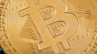 Eine rein digitale Währung: Die physische Darstellung von Bitcoin – wie hier als Münze mit einem Bitcoin-Logo – ist rein symbolisch. Die Währung selber existiert einzig als Datenreihe in der Blockchain. 