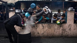 Auf Hilfe angewiesen: Palästinenser stehen für eine kostenlose Mahlzeit in der Grenzstadt Rafah im Gazastreifen an. 