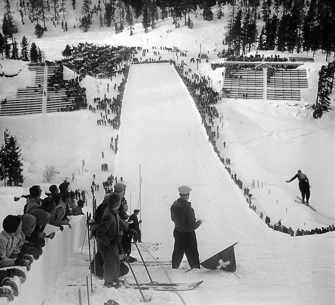 Von der Schanze ins Tal: Zuschauerinenn und Zuschauer verfolgen einen Skispringer an den Olympischen Spielen 1948 in St. Moritz.