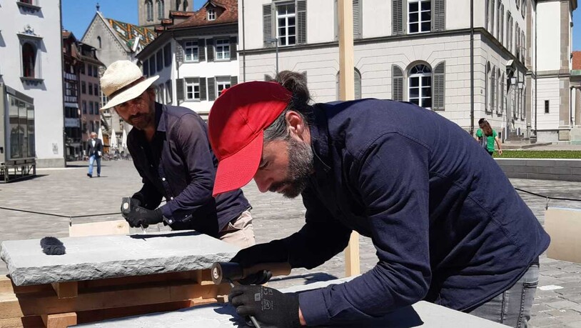 Frank (hinten) und Patrik Riklin arbeiten mit Meissel und Hammer an ihren "Zehn Geboten, Teil 2" in der St. Galler Altstadt.