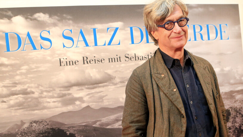 ARCHIV - Der Regisseur Wim Wenders steht bei der Premiere des Films "Das Salz der Erde" in der Lichtburg vor dem Filmplakat in Essen. Foto: Marcel Kusch/dpa