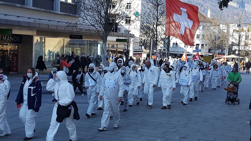 Der Demonstrationszug durch Chur am Samstag wurde angeführt von Personen in weissen Schutzanzügen.