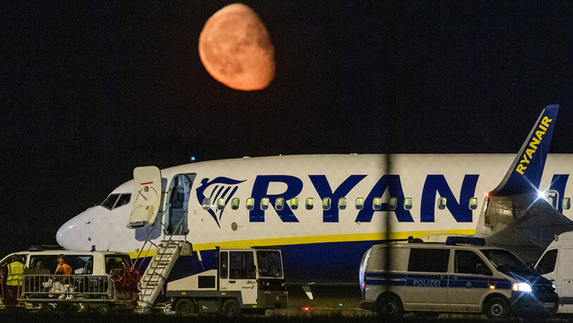 Die Bundespolizei überprüft nach einer außerplanmäßigen Landung einer Ryanair-Maschine am Berliner Hauptstadtflughafen BER das Flugzeug. Im Hintergrund ist der Mond zu sehen. Foto: Christophe Gateau/dpa Foto: Christophe Gateau/dpa