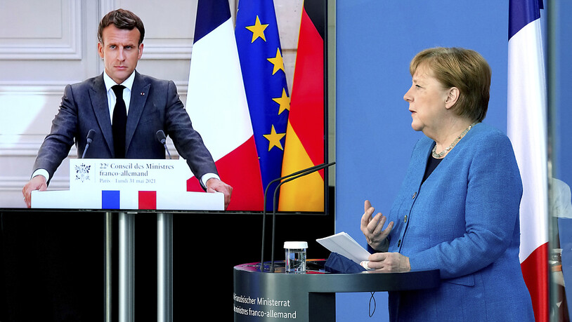 Frankreichs Präsident Emmanuel Macron ist bei einer gemeinsamen Pressekonferenz mit Bundeskanzlerin Angela Merkel auf einem Bildschirm zu sehen. Foto: Michael Sohn/POOL AP/dpa