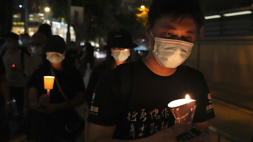 Menschen gehen mit Kerzen in den Händen vor dem Victoria Park entlang. Bereits in den vergangenen Jahren hatten sich dort etliche Menschen zum Jahrestag der blutigen Niederschlagung der Demokratiebewegung am 4. Juni 1989 in Peking versammelt. Foto: Kin…