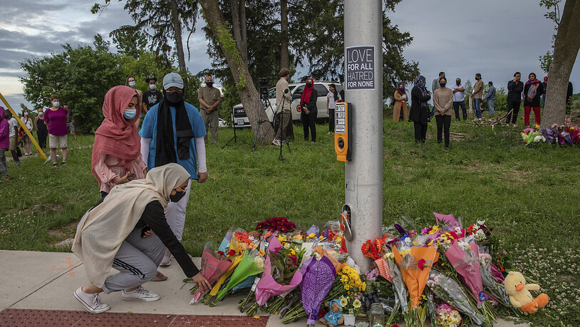 Trauernde legen Blumen an der Stelle ab, wo eine fünfköpfige Familie von einem Autofahrer angefahren wurde, in London, Ontario. Foto: Brett Gundlock/The Canadian Press via AP/dpa - ACHTUNG: Nur zur redaktionellen Verwendung und nur mit vollständiger…