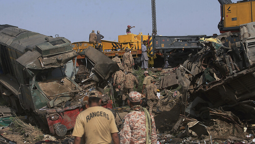 Soldaten kommen an, um die Strecke an der Stelle einer Zugkollision im Bezirk Ghotki im Süden Pakistans zu räumen. Foto: Fareed Khan/AP/dpa