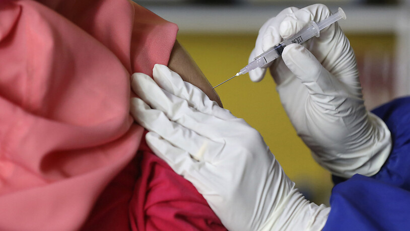 Eine Frau erhält bei einer Massenimpfung in Jakarta eine Spritze mit Impfstoff gegen das Coronavirus. Foto: Dita Alangkara/AP/dpa