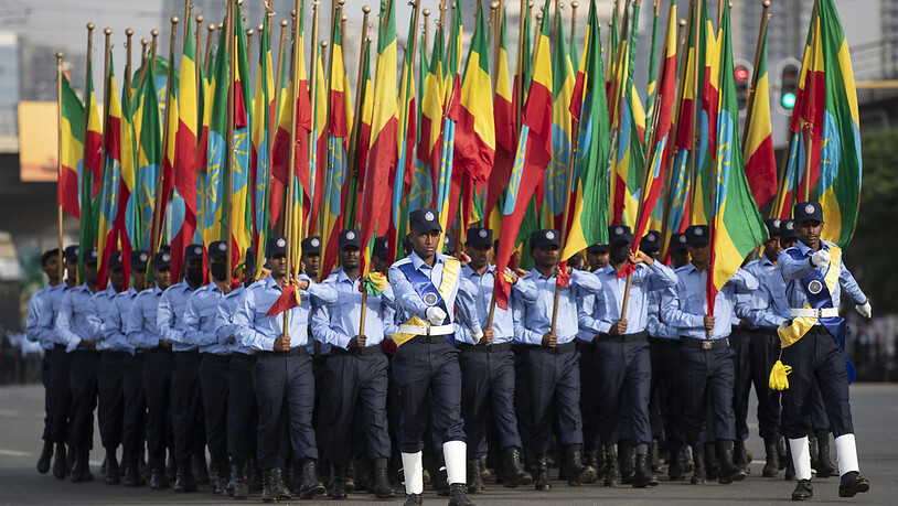 Äthiopische Polizisten, die Fahnen in den Farben der Nationalflagge halten, marschieren während einer Parade auf dem Meskel-Platz, um die neue Polizeiuniform zu präsentieren und an die Wahrung der Unparteilichkeit sowie das Respektieren des Gesetzes…