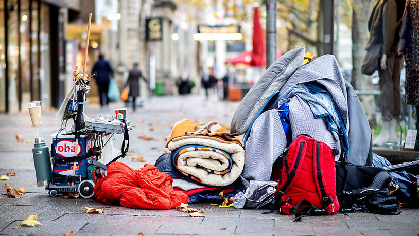 ARCHIV - Die Habseligkeiten eines Obdachlosen liegen auf einem Bürgersteig in der Innenstadt von Hannover. Foto: Hauke-Christian Dittrich/dpa