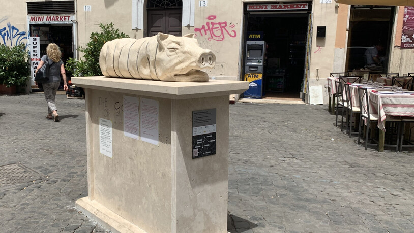 Die Skulptur eines Spanferkels Mitten im Ausgehviertel Trastevere in Rom. Foto: Johannes Neudecker/dpa