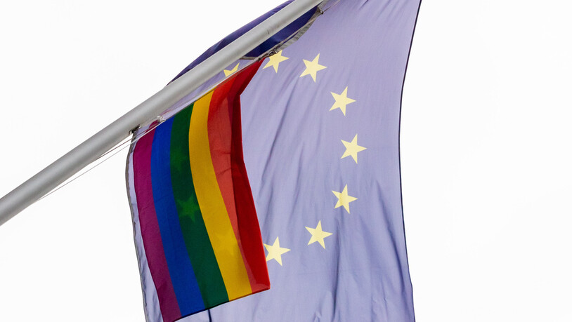 Eine Regenbogenfahne weht neben der EU-Flagge an der der Vertretung der Europäischen Kommission in Berlin. Foto: Christoph Soeder/dpa