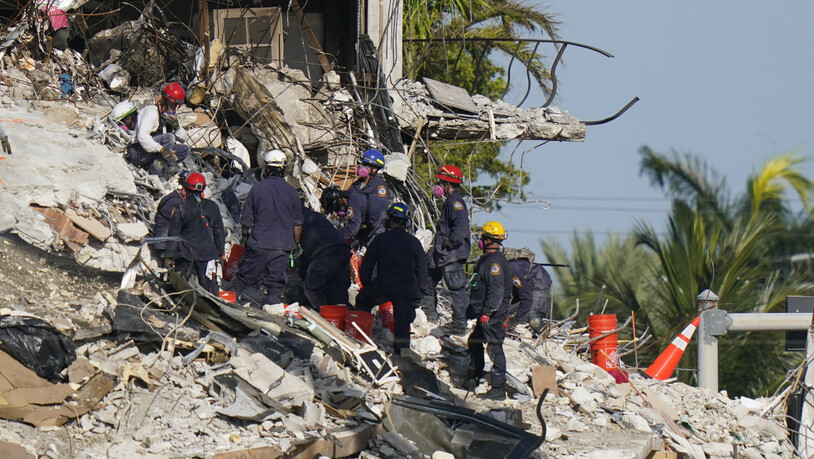Rettungskräfte durchsuchen die Trümmer des Champlain Towers. Nach dem Teileinsturz eines zwölfstöckigen Wohnhauses im US-Bundesstaat Florida sind in den Trümmern weitere Todesopfer gefunden worden. Foto: Lynne Sladky/AP/dpa