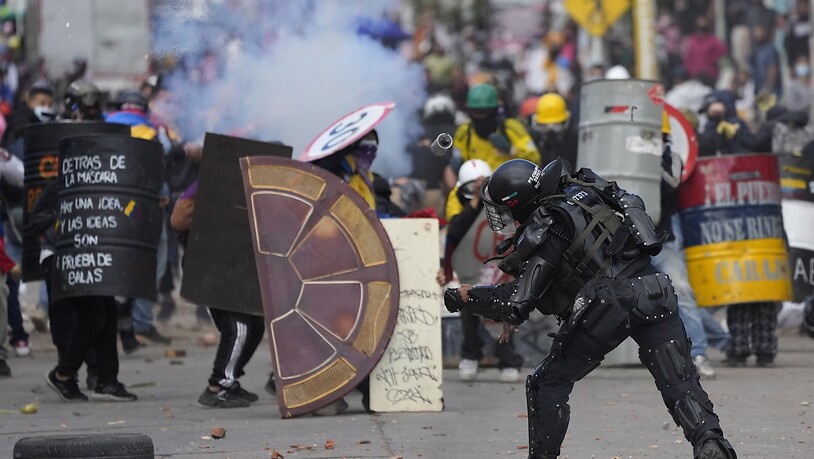 Ein Polizist wirft eine Blendgranate auf Demonstranten während anhaltender Anti-Regierungs-Proteste, die durch vorgeschlagene Steuererhöhungen auf öffentliche Dienstleistungen, Kraftstoff, Löhne und Renten in Bogota, Kolumbien, ausgelöst wurden. Foto:…