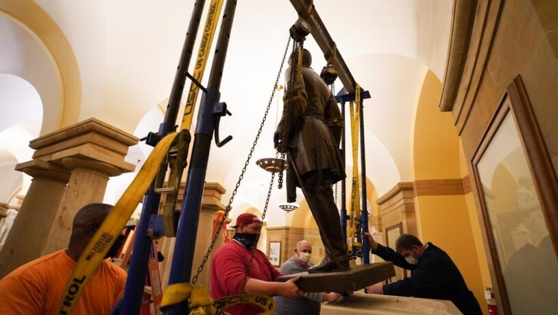 ARCHIV - Arbeiter entfernen eine Statue des Südstaaten-Generals Robert E. Lee aus dem Gebäude des US-Kongresses. Das US-Repräsentantenhaus hat für einen Gesetzentwurf gestimmt, der fordert, alle als rassistisch geltenden Statuen aus dem Kapitol zu…