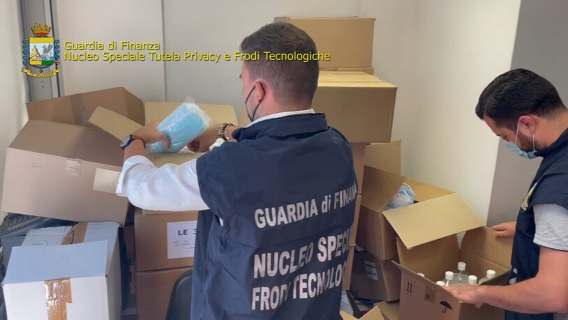 HANDOUT - Italienische Ermittler durchsuchen Pakete mit unter anderem Gesichtsmasken. Foto: Guardia di Finanza/dpa