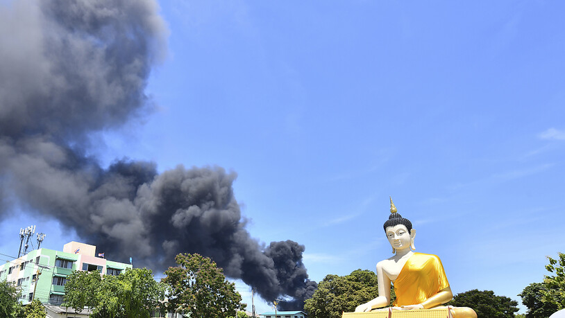 Rauch steigt hinter einer riesigen Buddha-Statue in der Provinz Samut Prakan auf. In Thailand ist es in einer Chemiefabrik zu einer schweren Explosion gekommen. Foto: Uncredited/AP/dpa