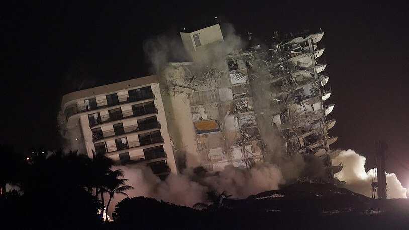 Die beschädigte Reststruktur des Champlain Towers South Condo Gebäudes stürzt ein. Nach dem Teileinsturz des Wohnkomplexes in der Nähe von Miami ist der noch stehende Gebäudeteil gesprengt werden. Die Ruine war instabil. Foto: Lynne Sladky/AP/dpa Foto:…