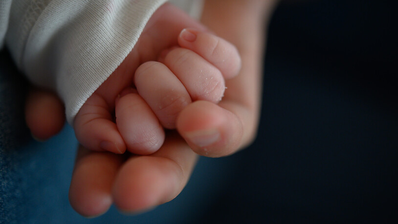 ARCHIV - Die Hand eines zwei Wochen altes Neugeborenen liegt in der Hand seiner Mutter. (Archivbild) Foto: Sebastian Gollnow/dpa
