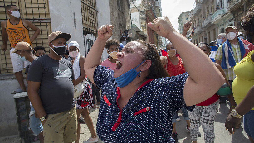 Eine Frau schreit Pro-Regierungs-Parolen, während Anti-Regierungs-Demonstranten in Havanna, Kuba, marschieren. Foto: Ismael Francisco/AP/dpa