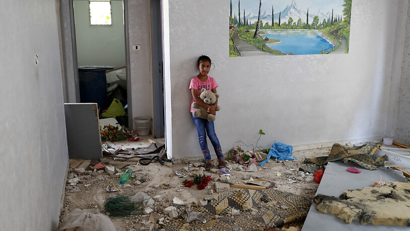 Die 10-jährige Rahaf Abu Fares, die vier Familienmitglieder verlor, als ihr Haus während des elftägigen Gefechts zwischen Israel und der Hamas im Mai von israelischer Artillerie bombardiert wurde, trägt einen Teddybär inmitten der Trümmer ihres Hauses im…