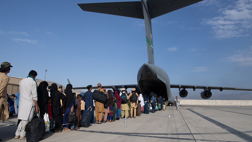 HANDOUT - Afghanische Flüchtlinge besteigen ein US-Militärflugzeug von Typ Boeing C-17 Globemaster III am Hamid Karzai International Airport. Foto: Msgt. Donald R. Allen/U.S. Air/Planet Pix via ZUMA Press Wire/dpa - ACHTUNG: Nur zur redaktionellen…