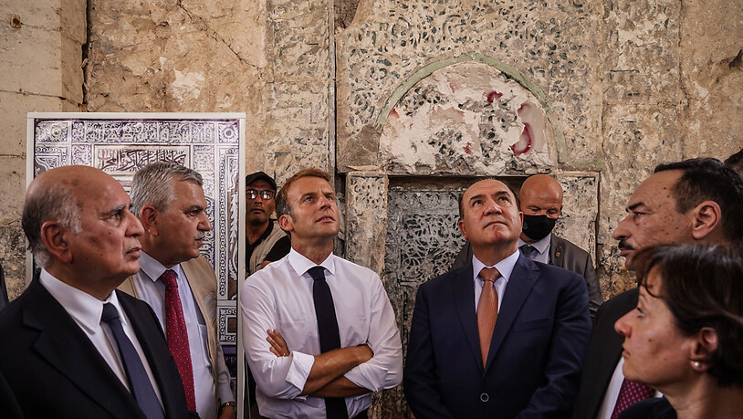 Emmanuel Macron (M), Präsident von Frankreich, besucht die Al-Nuri-Moschee in Mossul. Dabei sagt er der dortigen christlichen Minderheit Frankreichs Unterstützung zu. Foto: Ismael Adnan/dpa