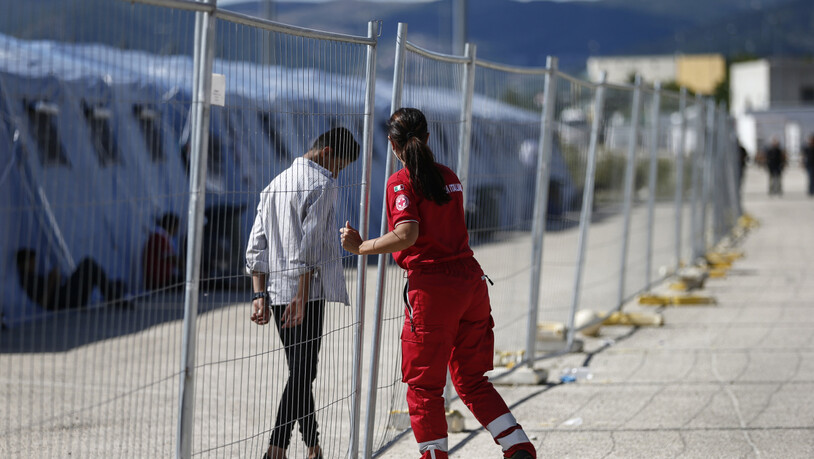 Ein geflüchteter Afghane geht an einem Zaun in einem Einsatzzentrum des italienischen Roten Kreuzes, Croce Rossa Italiana (CRI) in Avezzano. In dem Einsatzzentrum werden mit Hilfe der Armee und des Zivilschutzes afghanische Geflüchtete aufgenommen. Foto:…