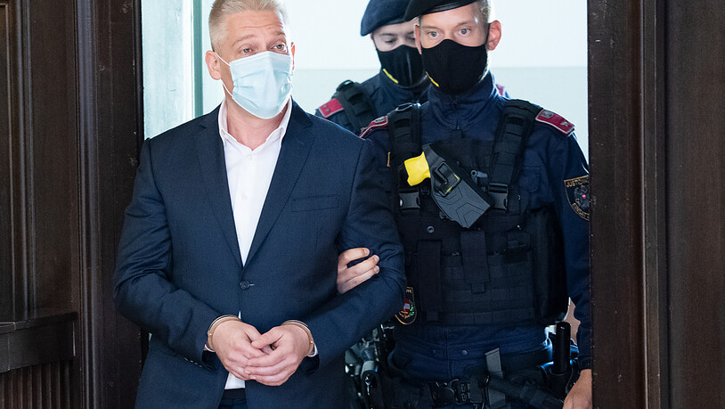 Beamte begleiten Julian Hessenthaler (l), Privatdetektiv aus Österreich, in den Gerichtssaal. Der mutmaßliche Drahtzieher in der Ibiza-Affäre ist außerdem wegen Drogenhandels angeklagt. Foto: Roland Schlager/APA/dpa