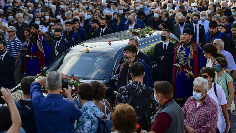 Menschen eskortieren einen Leichenwagen vor der Beerdigung des verstorbenen griechischen Komponisten Mikis Theodorakis. Theodorakis starb am 2. September 2021 im Alter von 96 Jahren. An diesem Donnerstag haben Tausende Kreter von dem Komponisten Abschied…