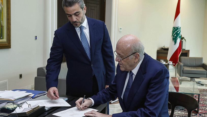 HANDOUT - Nadschib Mikati (r), Ministerpräsident des Libanon, unterzeichnet ein Dekret zur Bildung einer lang erwarteten Regierung mit 24 Ministern. Die vorherige Regierung war nach der Explosionskatastrophe im Hafen von Beirut vor mehr als einem Jahr…