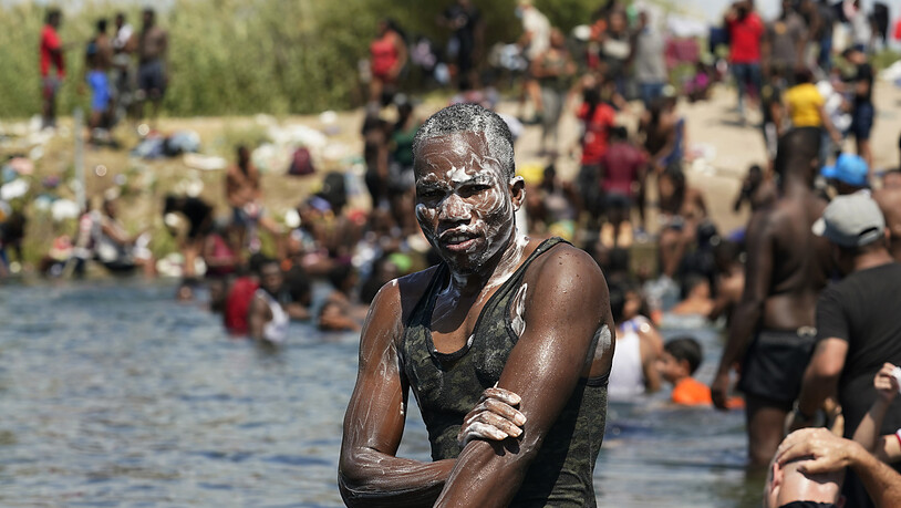 Ein haitianischer Migrant badet im Rio Grande nahe eines Dammes, an dem Migranten von Mexiko in die Vereinigten Staaten ein- und ausreisen. In der US-Grenzstadt Del Rio hat sich die Situation dramatisch zugespitzt. Dort harren Tausende Migranten unter…