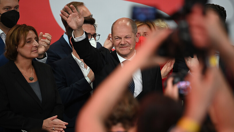 Olaf Scholz, Finanzminister und SPD-Kanzlerkandidat, winkt neben seiner Frau Britta Ernst während der Wahlparty im Willy-Brandt-Haus. Foto: Britta Pedersen/dpa