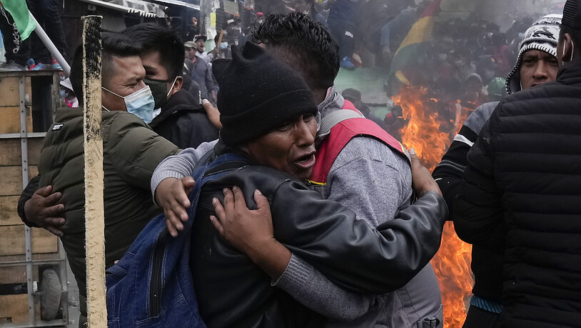Regierungsgegnerische Koka-Bauern umarmen sich nach einem Zusammenstoß mit der Polizei in der Nähe des Kokamarktes. Foto: Juan Karita/AP/dpa