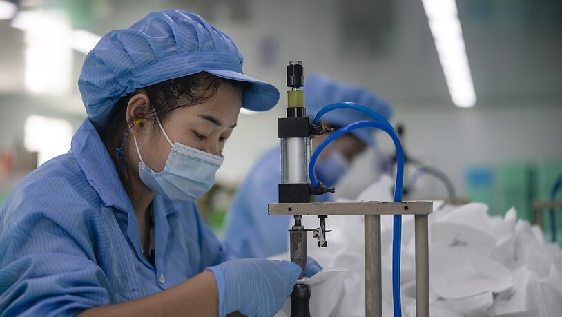 Eine Mitarbeiterin in einer chinesischen Fabrik stellt Schutzmasken her. Nach dem Coronaeinbruch wuchs die Wirtschaft in China schnell wieder. Doch das Wachstum hat sich im dritten Quartal wieder abgeschwächt. (Archivbild)