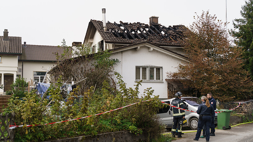 Polizisten vor dem vom tödlichen Brand betroffenen Wohnhaus in Leuzigen BE.
