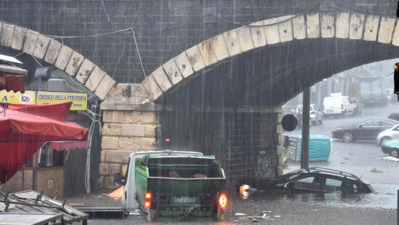 Fahrzeuge stehen auf einer überschwemmten Straße in Catania. Bislang haben während der Unwetter und Überflutungen der vergangenen Tage drei Menschen auf Sizilien ihr Leben verloren. Foto: Orietta Scardino/ANSA via ZUMA Press/dpa