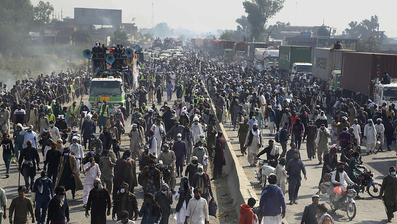 Anhänger der radikal-islamistischen Partei Tehreek-e Labbaik Pakistan (TLP) nehmen an einem Protestmarsch in Richtung Islamabad auf einer Landstraße teil. Foto: K.M. Chaudary/AP/dpa